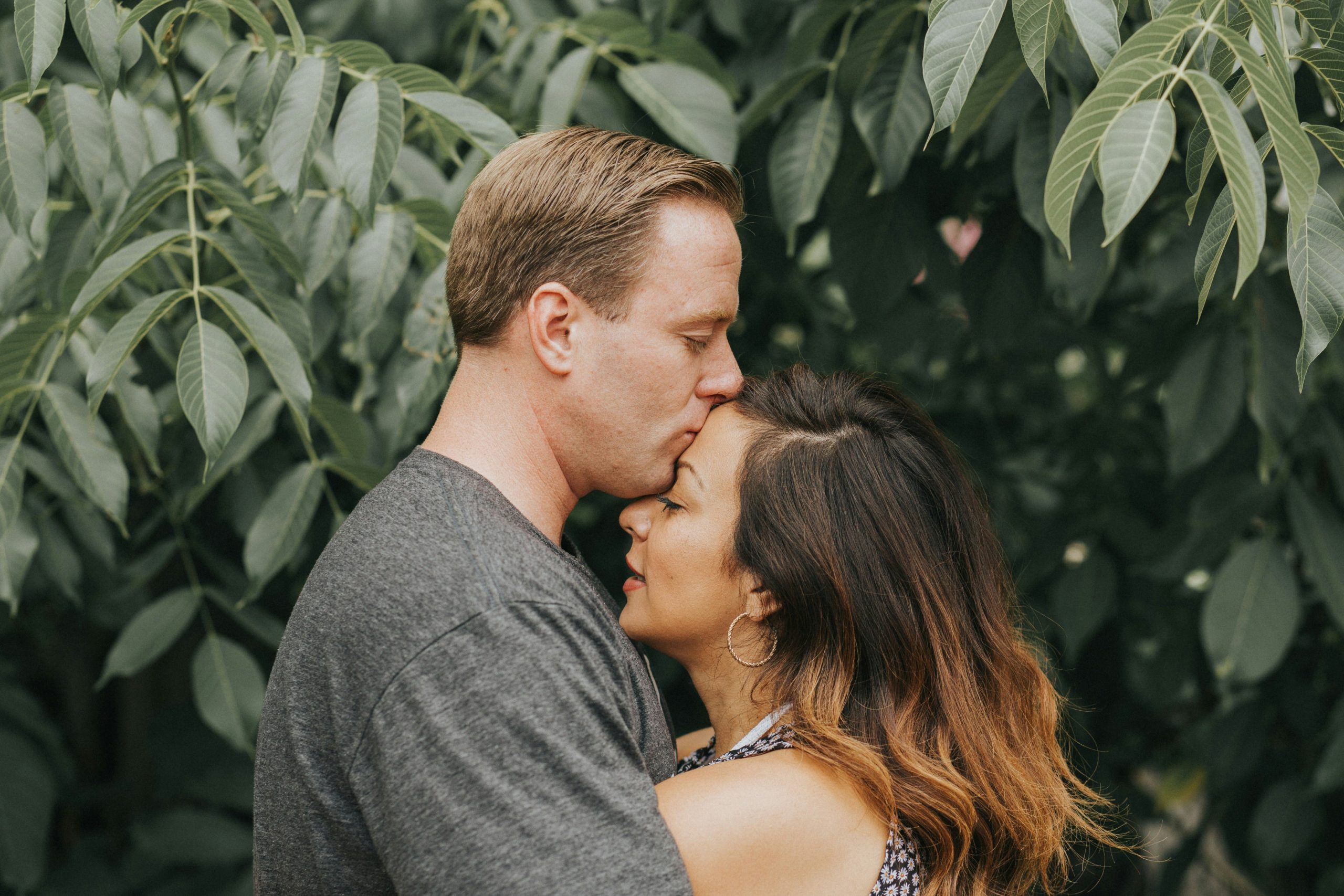 Ashley and Caleb embracing, showing a tender moment between a middle-aged woman and her younger husband. Emotional intimacy, love, and relationship dynamics captured in a candid outdoor photo.