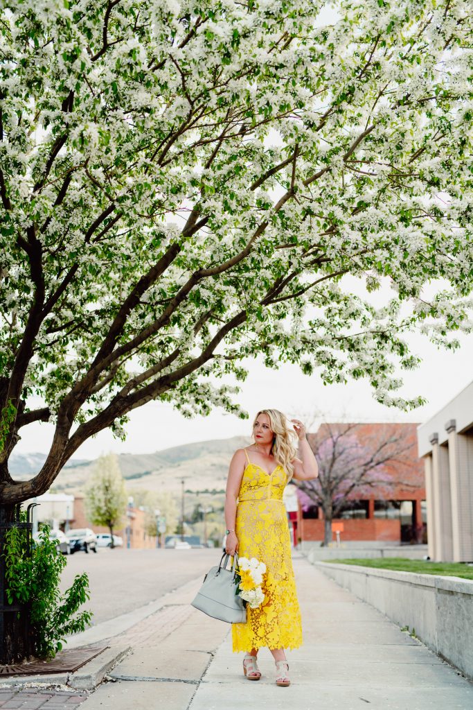 June Moore standing beneath a flowering tree