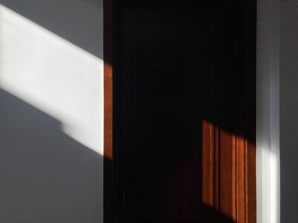 A doorway casting a strong shadow across a neutral wall