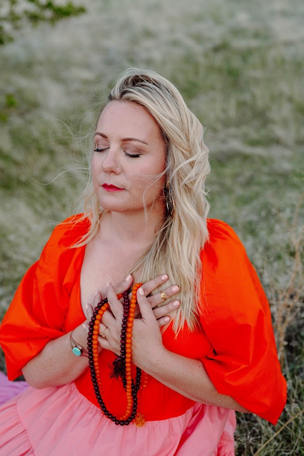 June Moore outdoors wearing a coral top